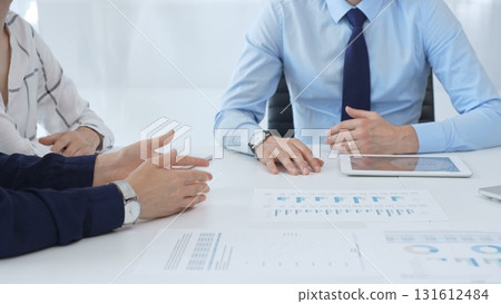 Business people reviewing financial metrics on digital screens, collaborating strategically while examining charts and graphs in office 131612484
