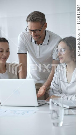 Business people collaborating and analyzing data on a laptop during an office meeting Business people collaborating and analyzing data on a laptop during an office meeting 131612624