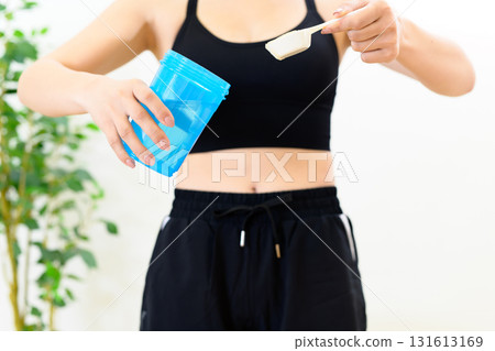 運動後，女性將蛋白粉放入搖壺，底部有空間 131613169