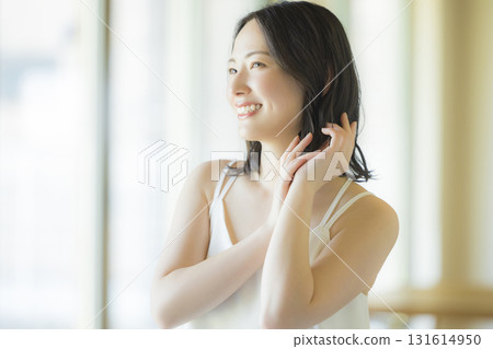 A woman doing hair care in the living room 131614950