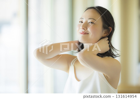 A woman doing hair care in the living room 131614954