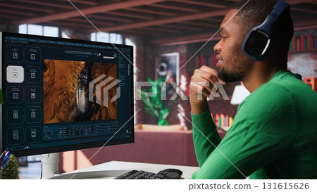 Computer screen displays digital visuals generated through AI. Young person uses software combining data and machine learning, text prompts to design graphics at home office. Camera B. 131615626