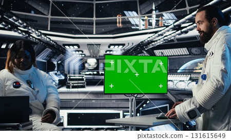 Researchers flying together in starship, looking at green screen monitor, exploring Mars. Cosmonauts using mockup display to ensure operational readiness before landing on red planet 131615649