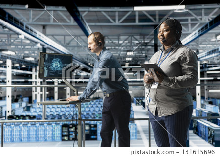 Team of data center IT professionals assisting users with AI troubleshooting, delivering technical support. Server farm colleagues chatting in headset microphone with users in need of assistance 131615696
