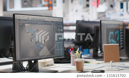 Monitor on desk in photovoltaics factory running software update, robot arms placing solar panels on assembly lines. PC display in empty manufacturing plant used for solar cell machinery. Monitor on desk in photovoltaics factory running software update, robot arms placing solar panels on assembly lines. PC display in empty manufacturing plant used for solar cell machinery. 131615702