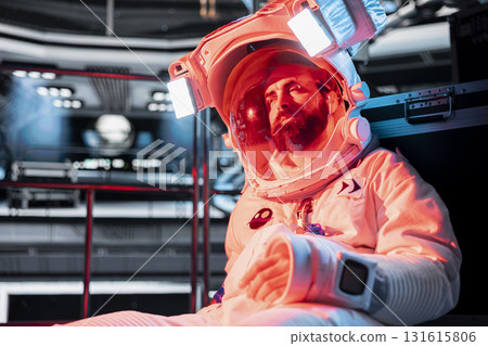 Astronaut sees red light error in spacecraft during space travel to other planets habitats. Cosmonaut in futuristic starship suffering malfunctions during cosmic journey to support future colonization Astronaut sees red light error in spacecraft during space travel to other planets habitats. Cosmonaut in futuristic starship suffering malfunctions during cosmic journey to support future colonization 131615806