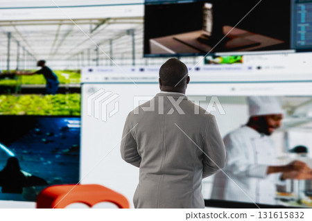 Man facing digital video wall, benefiting from endless entertainment selection. Viewer enjoying access to various streaming options, looking at screens displaying movies and TV shows clips Man facing digital video wall, benefiting from endless entertainment selection. Viewer enjoying access to various streaming options, looking at screens displaying movies and TV shows clips 131615832