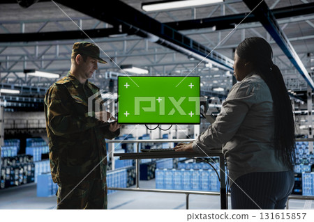 IT specialist briefing commander in army server hub using isolated screen monitor. Military officer in data center and engineer monitoring warfare drone telemetry using chroma key display 131615857