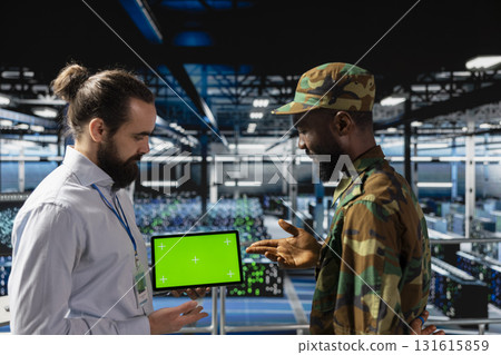 Army control center engineering team using chroma key copy space on tablet, working on national defense mission on industrial platform in control room base. Defend networks against threats. 131615859