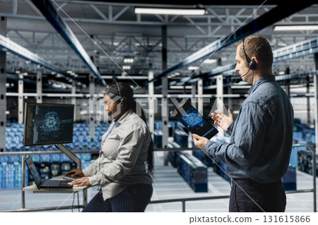 Server hub engineers providing remote tech support using headset and artificial intelligent tools. Teamworking employees coordinating IT maintenance tasks using AI technology Server hub engineers providing remote tech support using headset and artificial intelligent tools. Teamworking employees coordinating IT maintenance tasks using AI technology 131615866