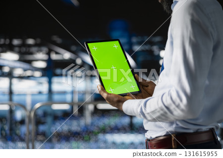 Male technician overseeing neural network using chroma key on tablet, reviewing LLM visualization. Server farm IT expert oversee rigs powering machine learning processes, industrial platform. 131615955