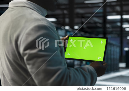 Close up of system administrator in data center using green screen tablet to check for server performance issues. IT specialist in server farm fixing errors slowing down hardware using mockup device 131616006