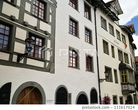 Historic buildings along a charming street in a quaint village showcasing traditional architecture and vibrant windows Historic buildings along a charming street in a quaint village showcasing traditional architecture and vibrant windows 131617024