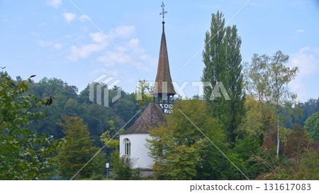 Charming chapel surrounded by trees in a lush landscape during a clear day Charming chapel surrounded by trees in a lush landscape during a clear day 131617083