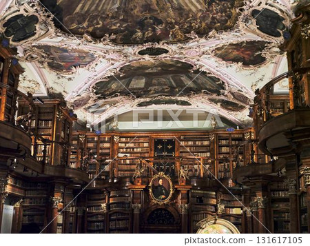 Majestic library interior with ornate ceilings and rows of vintage books during daylight hours 131617105