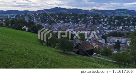 Scenic view of a Swiss town at sunset with green hills and historical buildings 131617106