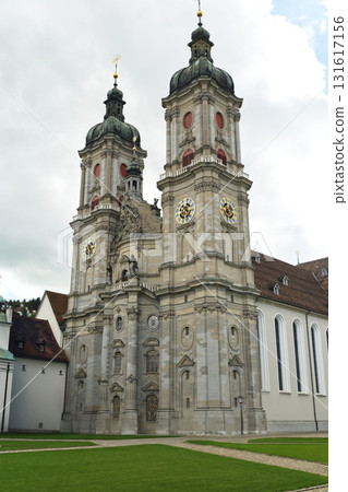Historic church with twin towers and detailed architecture located in Switzerland during a cloudy day Historic church with twin towers and detailed architecture located in Switzerland during a cloudy day 131617156