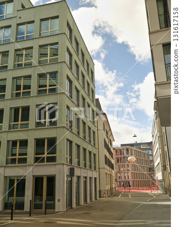 Modern architecture lines the streets in a contemporary urban setting under a bright blue sky Modern architecture lines the streets in a contemporary urban setting under a bright blue sky 131617158