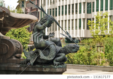 Statue of a figure riding a turtle, located near a fountain in a city square Statue of a figure riding a turtle, located near a fountain in a city square 131617177