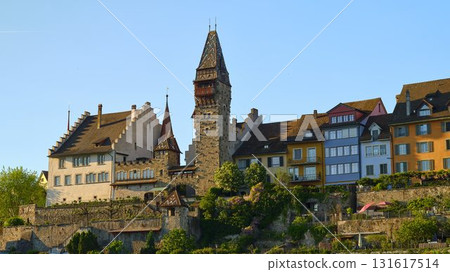 Historic castle overlooking scenic waterfront in quaint town during golden hour 131617514