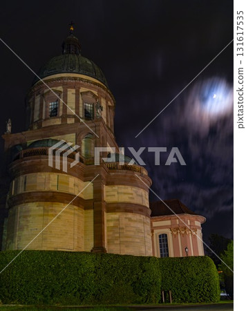 Historic building under moonlit sky with clouds, showcasing architectural details at night 131617535