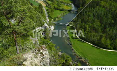 Lush green landscape with a river winding through the valley on a bright sunny day 131617539