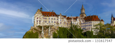 Historic castle perched on a hilltop under a vibrant blue sky during late afternoon 131617547