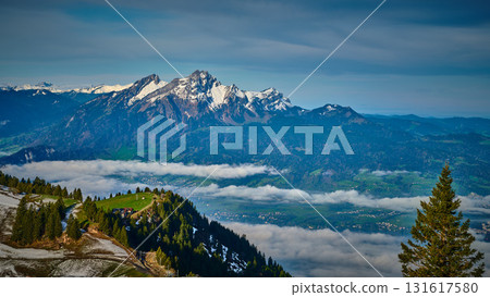 Scenic view of snow-capped mountains and green valleys in Switzerland during a clear day 131617580