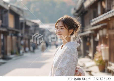 一位身穿浴衣的女子站在一條有連棟別墅的小巷裡 一位身穿浴衣的女子站在一條有連棟別墅的小巷裡 131618252