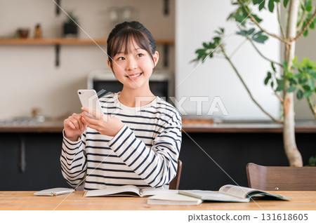 Elementary school student, junior high school girl, child studying at home using smartphone Elementary school student, junior high school girl, child studying at home using smartphone 131618605