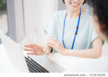 一位女銷售員佩戴名牌向顧客或同事解釋或會面的令人耳目一新的形象。 一位女銷售員佩戴名牌向顧客或同事解釋或會面的令人耳目一新的形象。 131619200