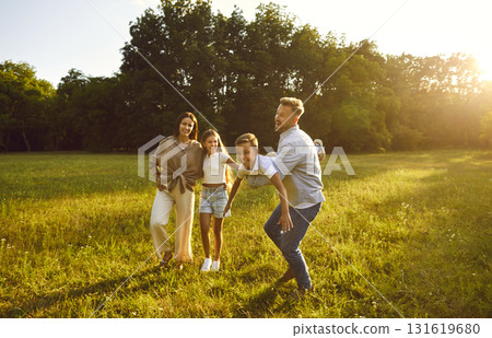 Happy young family of four with two kids having fun in summer park at sunset. Happy young family of four with two kids having fun in summer park at sunset. 131619680