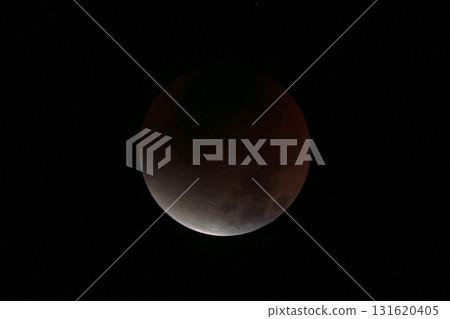 A total lunar eclipse floating in the night sky 131620405