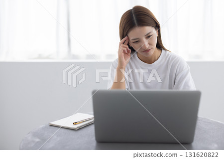 Woman suffering from headache while working on computer Woman suffering from headache while working on computer 131620822