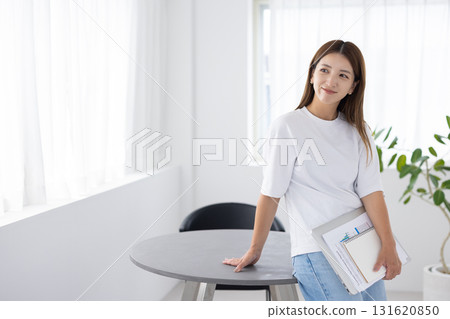 微笑的女人拿著筆記型電腦和文件 131620850