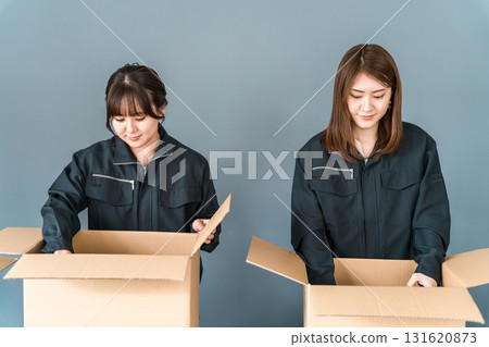A woman working as a transportation, logistics, courier, distribution, delivery, or delivery company packing boxes into cardboard boxes A woman working as a transportation, logistics, courier, distribution, delivery, or delivery company packing boxes into cardboard boxes 131620873
