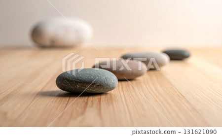 Smooth gray zen stones stacked for balance and harmony on a wooden table 131621090