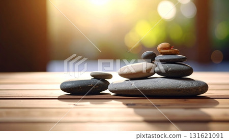Smooth gray zen stones stacked for balance and harmony on a wooden table 131621091