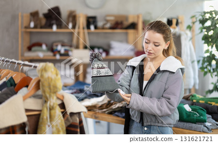 Young woman near showcase examine goods, hat. 131621721