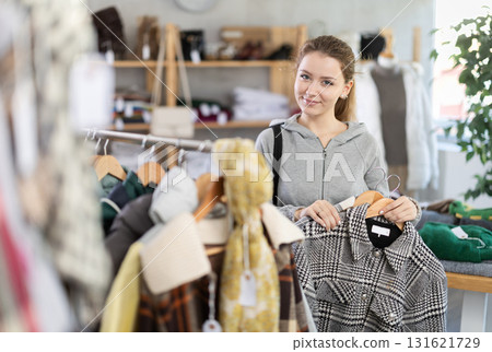 Young woman chooses jacket in clothing store Young woman chooses jacket in clothing store 131621729
