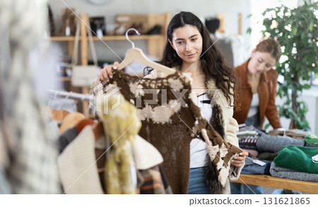 Young woman choosing cardigan in clothing store 131621865