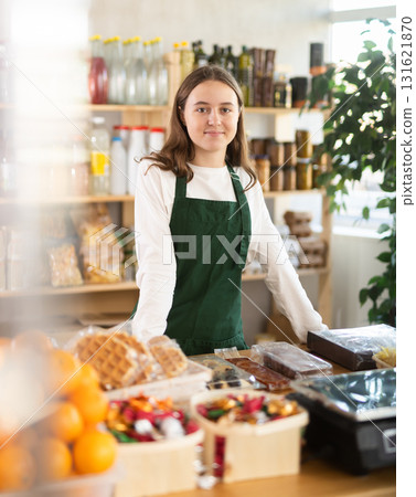 Teenage girl seller at counter in grocery store 131621870