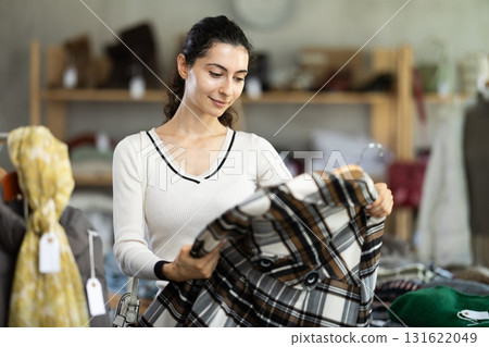 Armenian woman choosing a flannel plaid shirt Armenian woman choosing a flannel plaid shirt 131622049