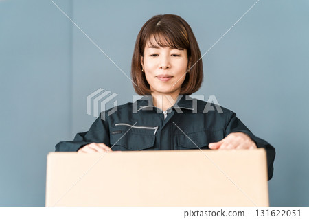 Female worker of transportation, logistics, courier, distribution, delivery, and delivery company packing boxes into cardboard boxes Female worker of transportation, logistics, courier, distribution, delivery, and delivery company packing boxes into cardboard boxes 131622051