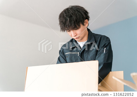 Male worker of transportation, logistics, courier, distribution, delivery, and delivery company packing boxes into cardboard boxes Male worker of transportation, logistics, courier, distribution, delivery, and delivery company packing boxes into cardboard boxes 131622052