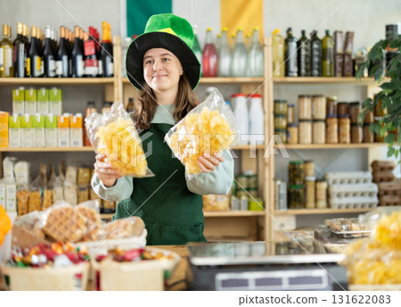 Teenage girl seller offers chips in grocery store Teenage girl seller offers chips in grocery store 131622083