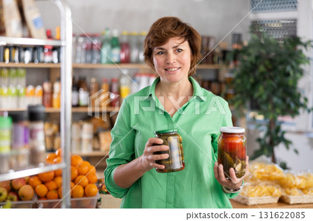 Woman chooses tomatoes and cucumbers in a marinade Woman chooses tomatoes and cucumbers in a marinade 131622085