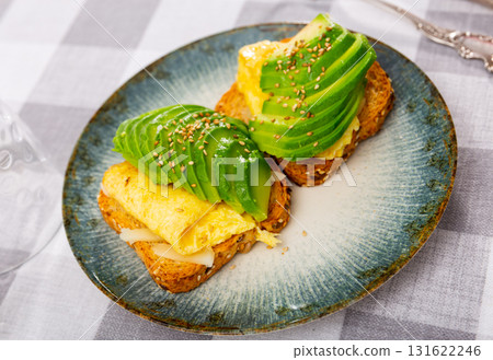 Toasts with avocado cheese and scrambled eggs 131622246