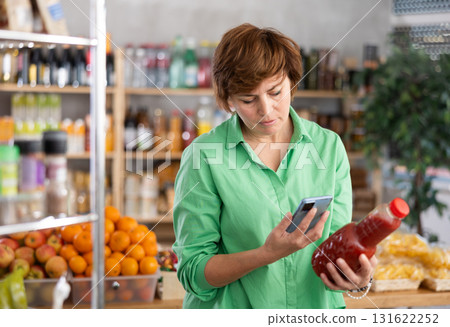 Adult woman scanning tomato juice Adult woman scanning tomato juice 131622252