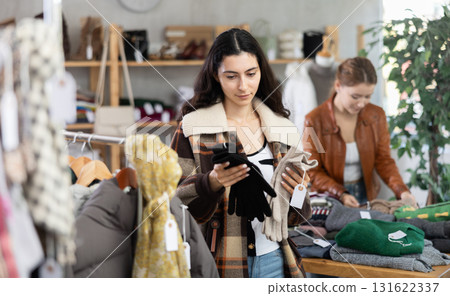 Young woman choosing gloves in clothing store 131622337